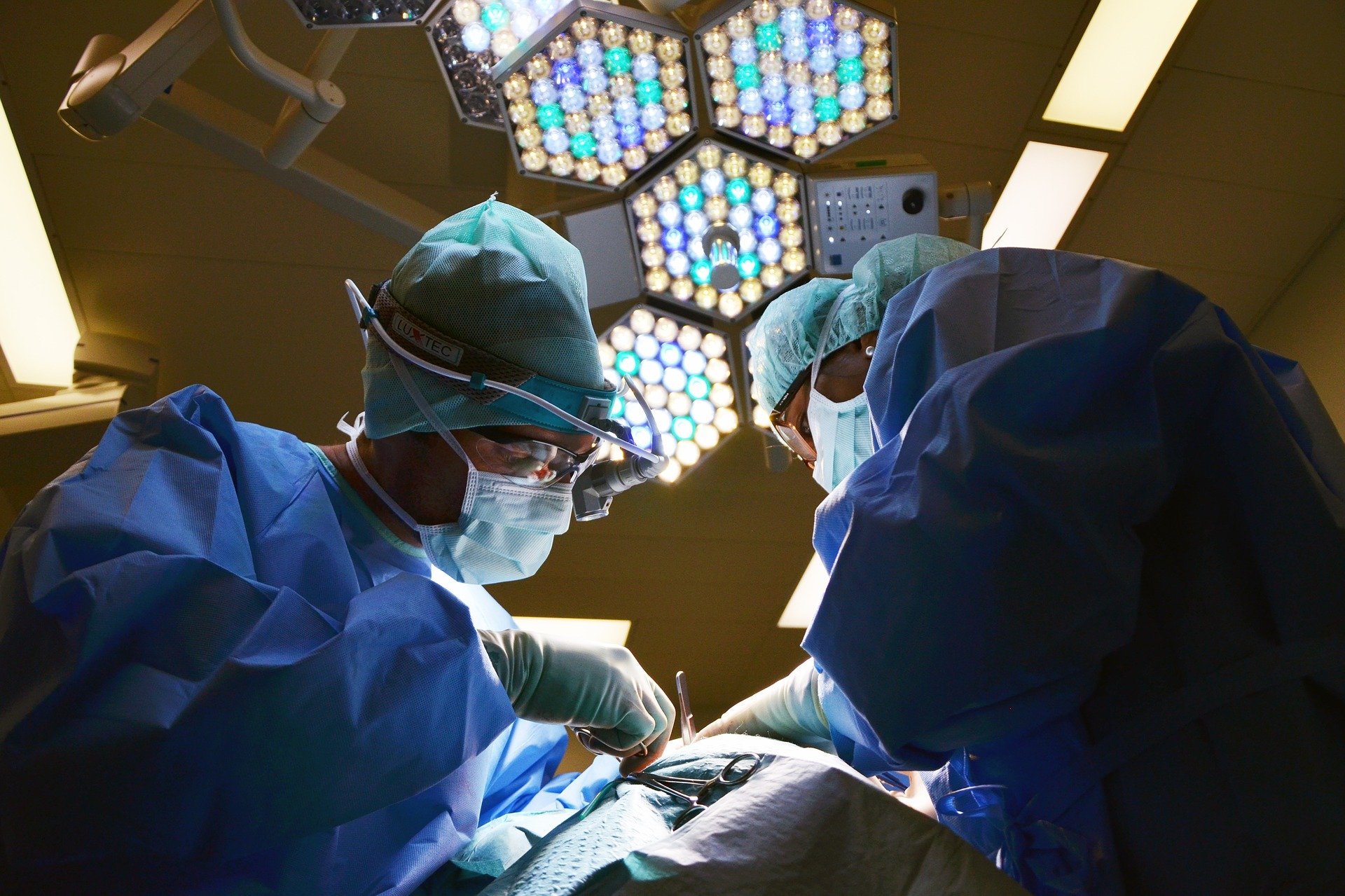 Zdjęcie przedstawia lekarzy prowadzących operację na sali operacyjnej szpitala